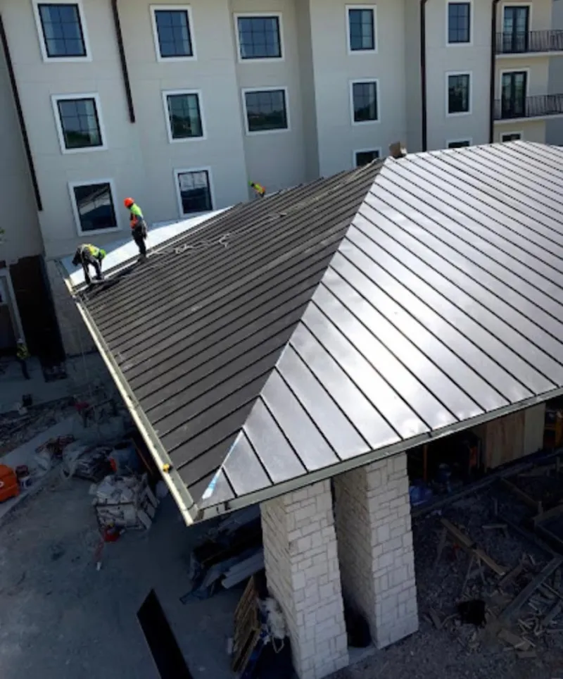 Crew installing standing seam metal roof panels on a commercial project in Ripon